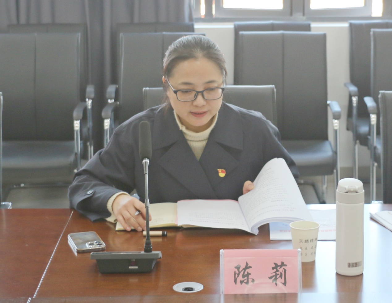 桌子前坐着穿蓝色上衣的人在打电话低可信度描述已自动生成